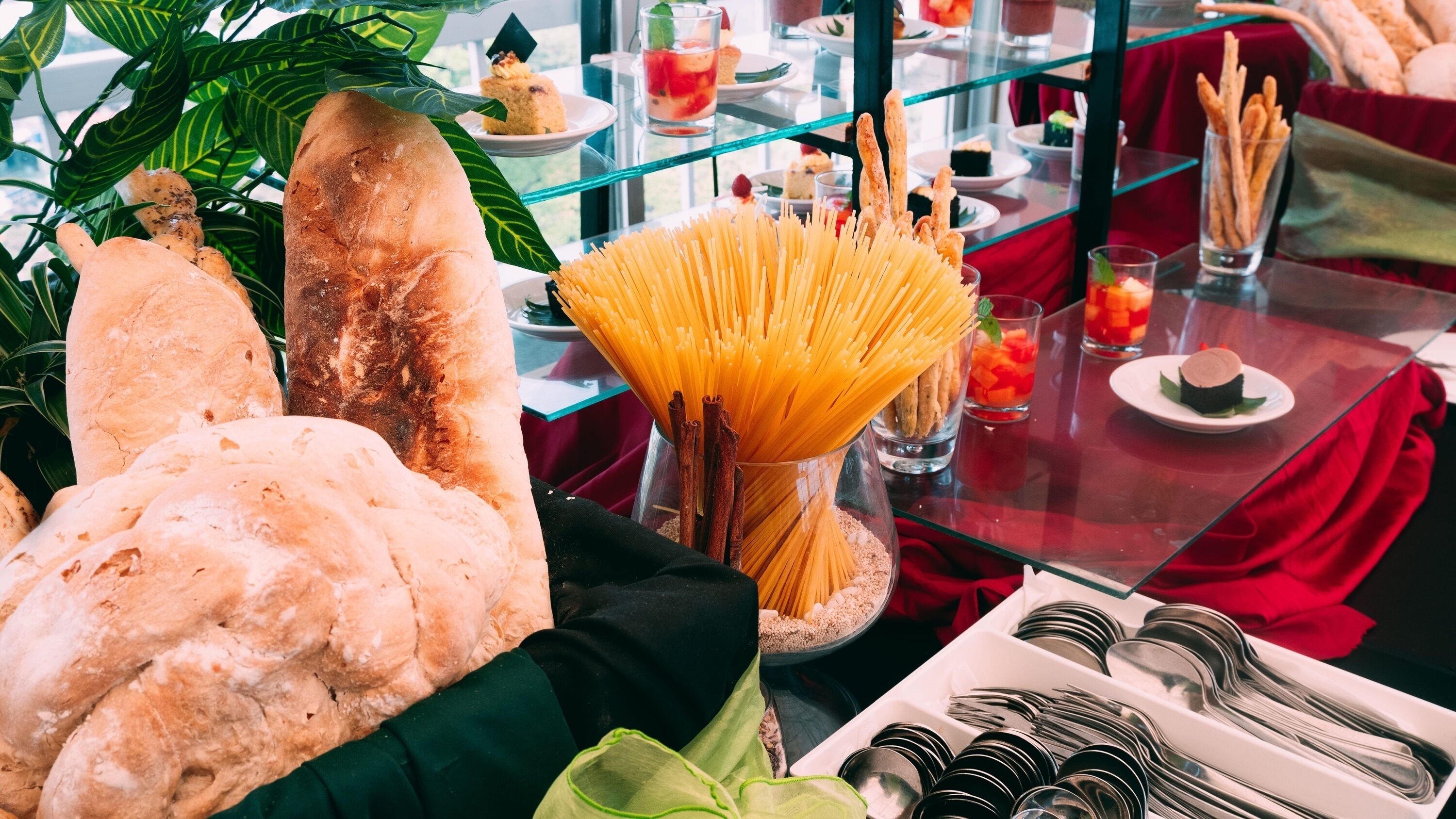 A buffet table with various food items including bread, pasta, and a variety of dishes.