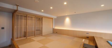 A modern interior with tatami flooring, a sliding door, and a low wooden bench.