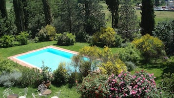 Una piscina al aire libre de temporada, sillones reclinables de piscina