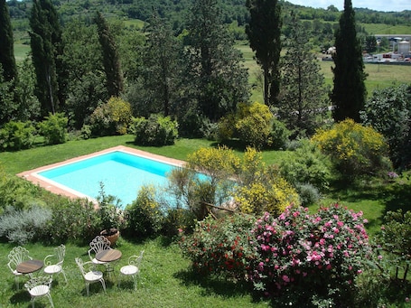 Una piscina al aire libre de temporada, sillones reclinables de piscina