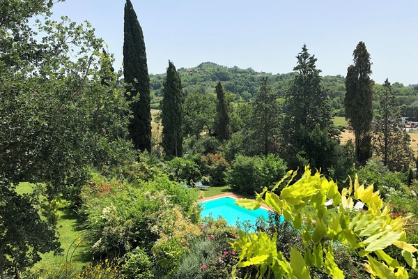Een seizoensgebonden buitenzwembad, ligstoelen bij het zwembad
