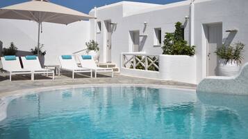 Relax by the serene pool surrounded by lush greenery and comfortable lounge chairs.