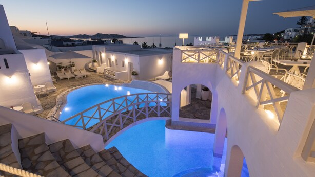 A rooftop pool area with white architecture, stone steps, and outdoor seating. - Kanale's Rooms and Suites (Paros)