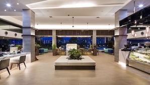 A spacious lobby with a central seating area, multiple dining tables, and a large display case. - ONE15 Marina Hotel Sentosa Cove (Singapore)