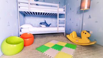 A child's bunk bed with a shark plush toy, a lamp, and a rocking horse.