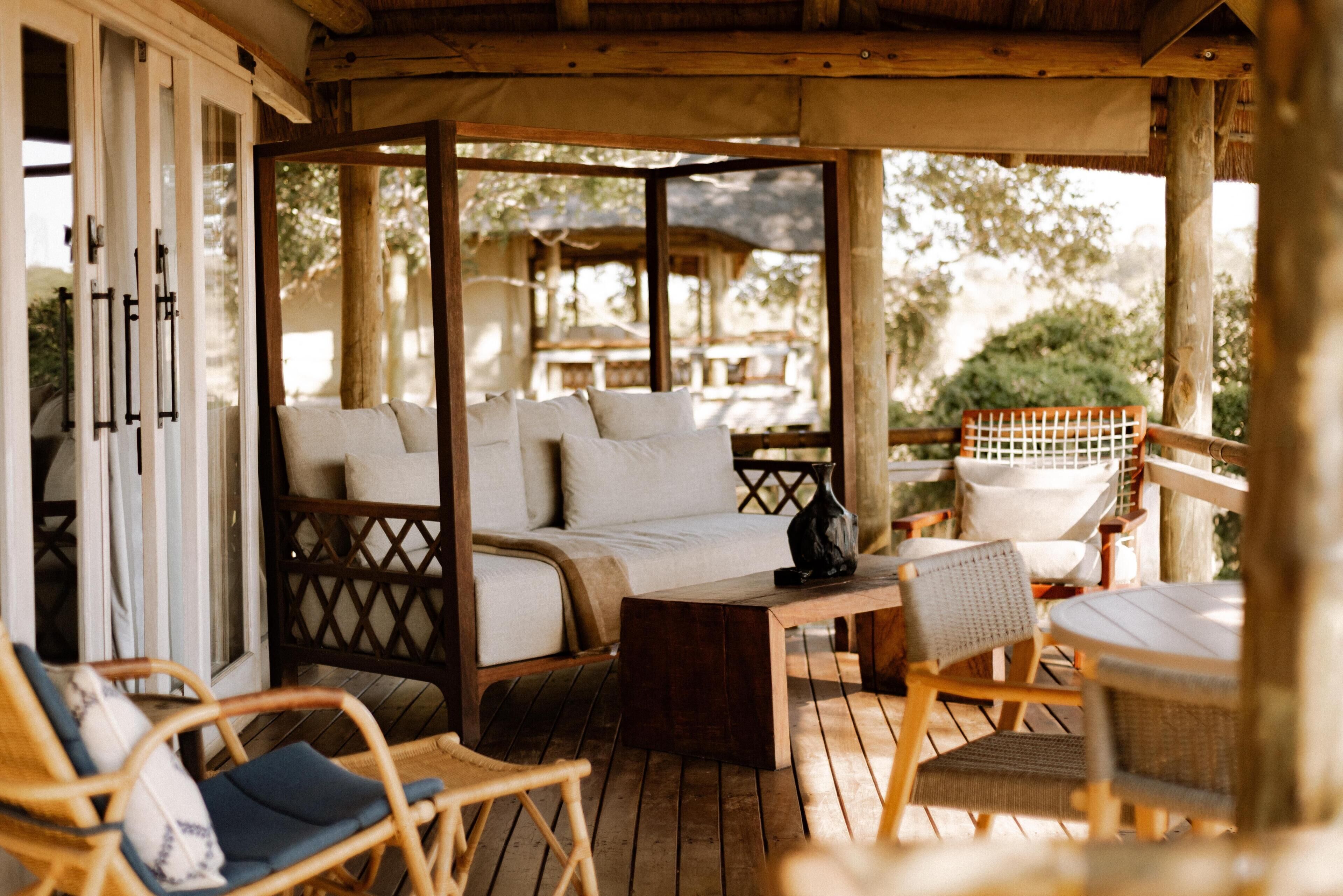 A wooden deck with a sofa, chairs, and a table.