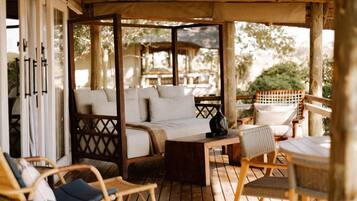 A wooden deck with a sofa, chairs, and a table.