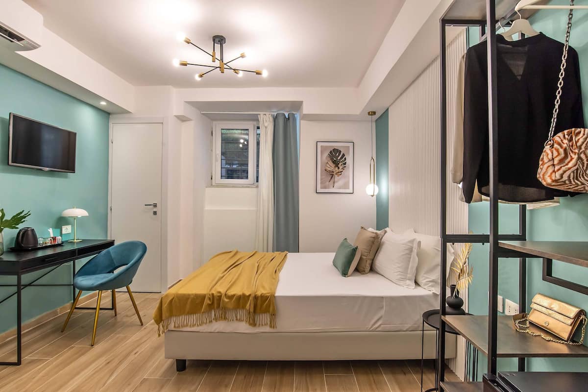 Une chambre à coucher moderne, équipée d’un lit, d’un bureau, d’une chaise et d’un téléviseur.