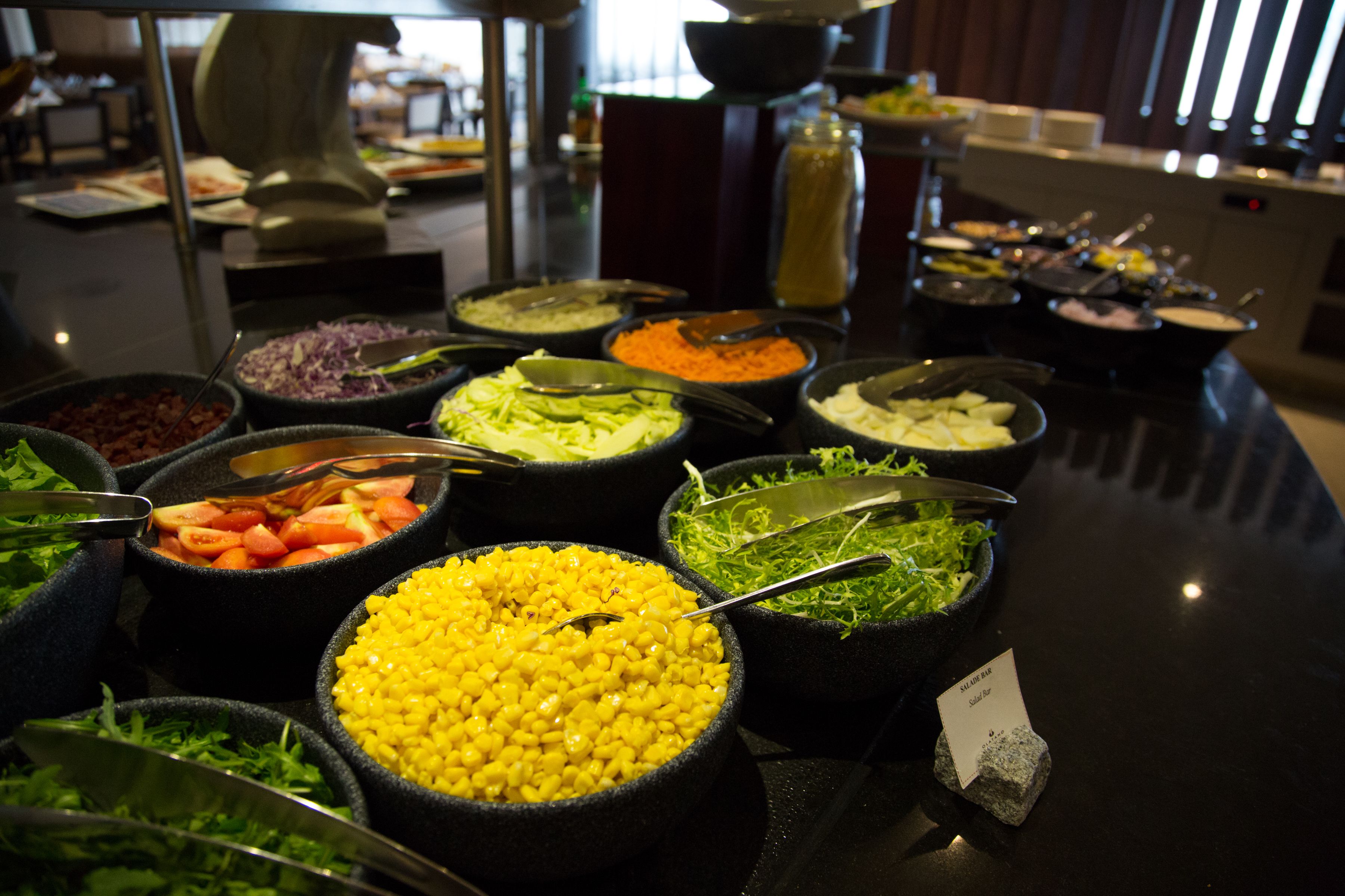 A buffet with various food options including salads, grains, and vegetables.