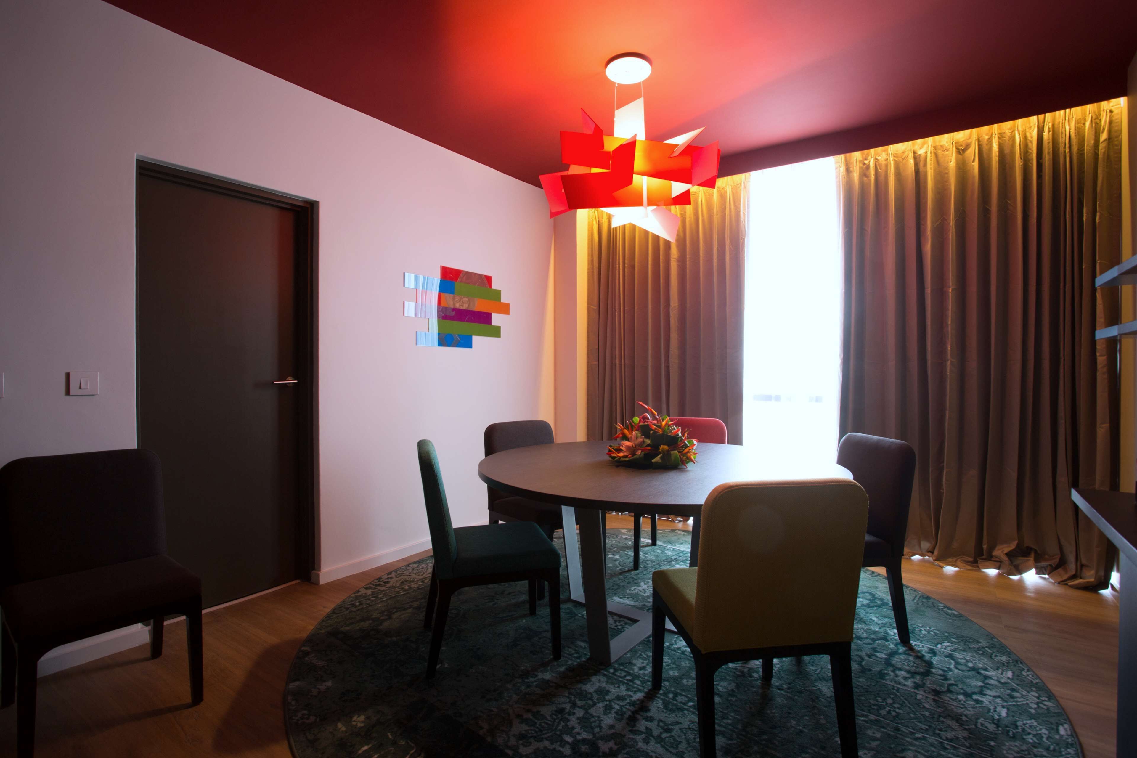 Un espace repas moderne avec une table ronde, des chaises et un élément décoratif central.