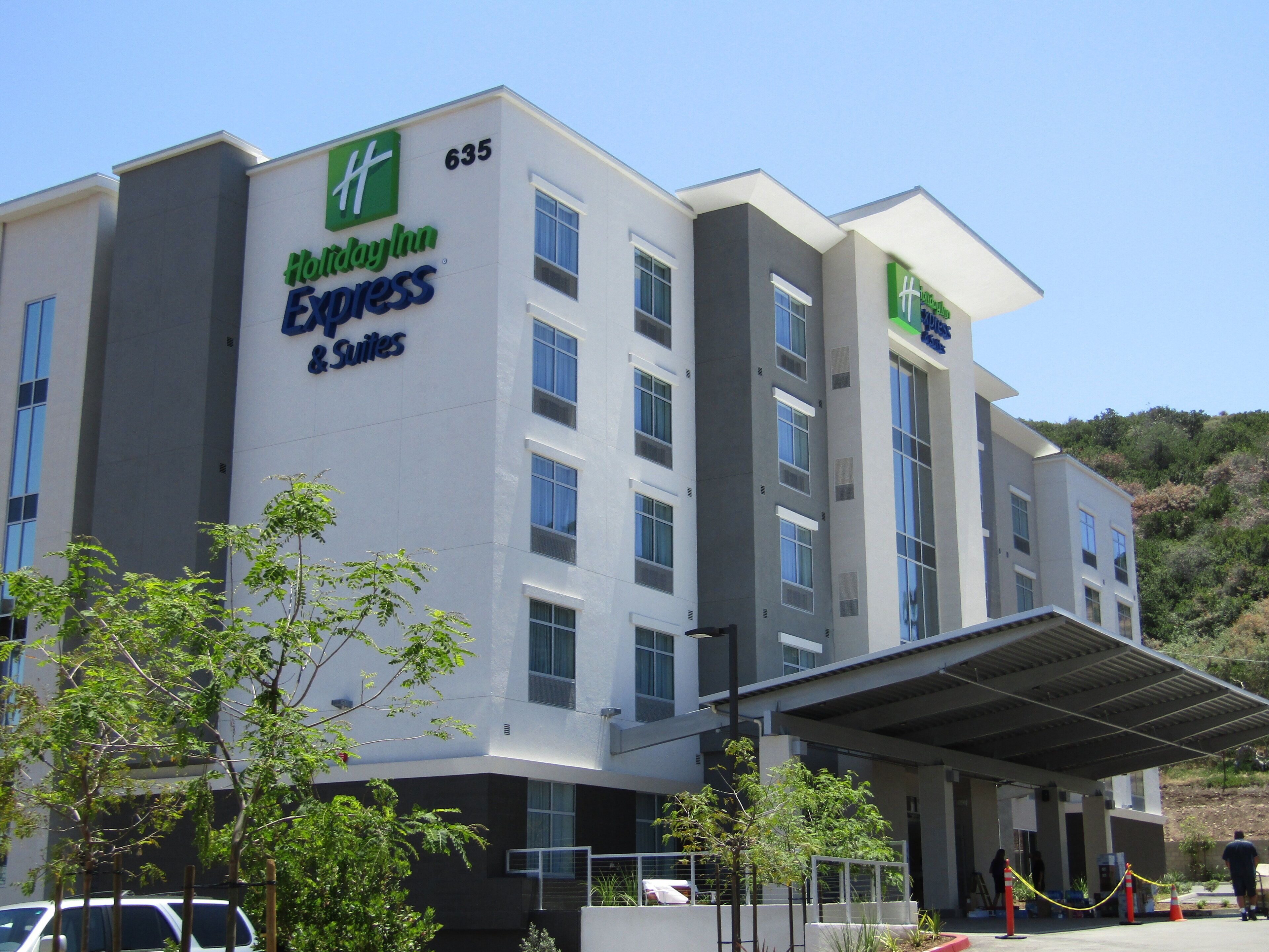 A Holiday Inn Express & Suites building with a flat facade, multiple windows, and a covered entrance area.