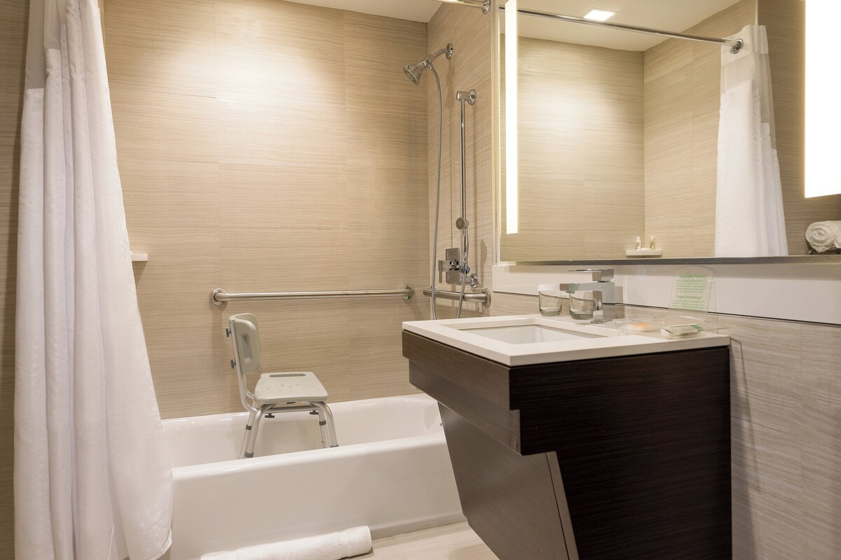 Un baño moderno con bañera, ducha, tocador y espejo.