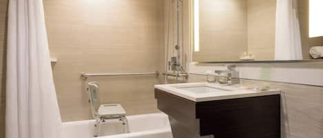 Un baño moderno con bañera, ducha, tocador y espejo.