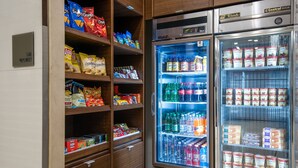 Un distributeur automatique rempli d’en-cas et de boissons, notamment des chips, des sodas et de l’eau en bouteille.