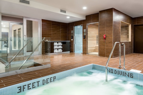 Zona de piscina interior moderna con un cartel de 'NO DIVING', barandillas de vidrio e indicador de profundidad de '3 PIES'.