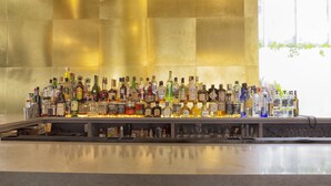 Un bar où l’on trouve une grande variété de bouteilles d’alcool et de verres.