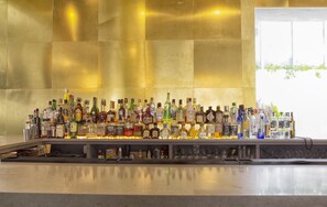 Un bar con una variedad de botellas de licor y vasos.