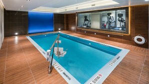 A swimming pool with a no diving sign, exercise equipment, and a blue accent wall. - Holiday Inn Brooklyn Downtown by IHG (Brooklyn)