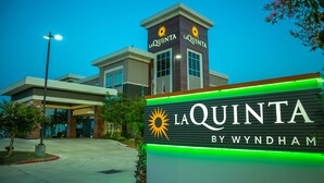 Exterior do hotel La Quinta by Wyndham, com uma placa de destaque exibindo o nome do hotel e o logotipo do sol.
