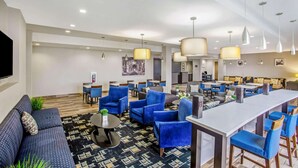 Um lobby de hotel moderno com área de estar, bar e espaço para refeições.
