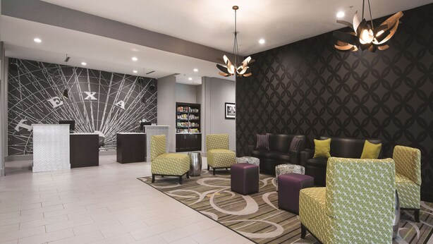 A modern lobby with a reception desk, seating area, and a patterned wall. - La Quinta Inn & Suites by Wyndham Fort Worth West - I-30 (Fort Worth)