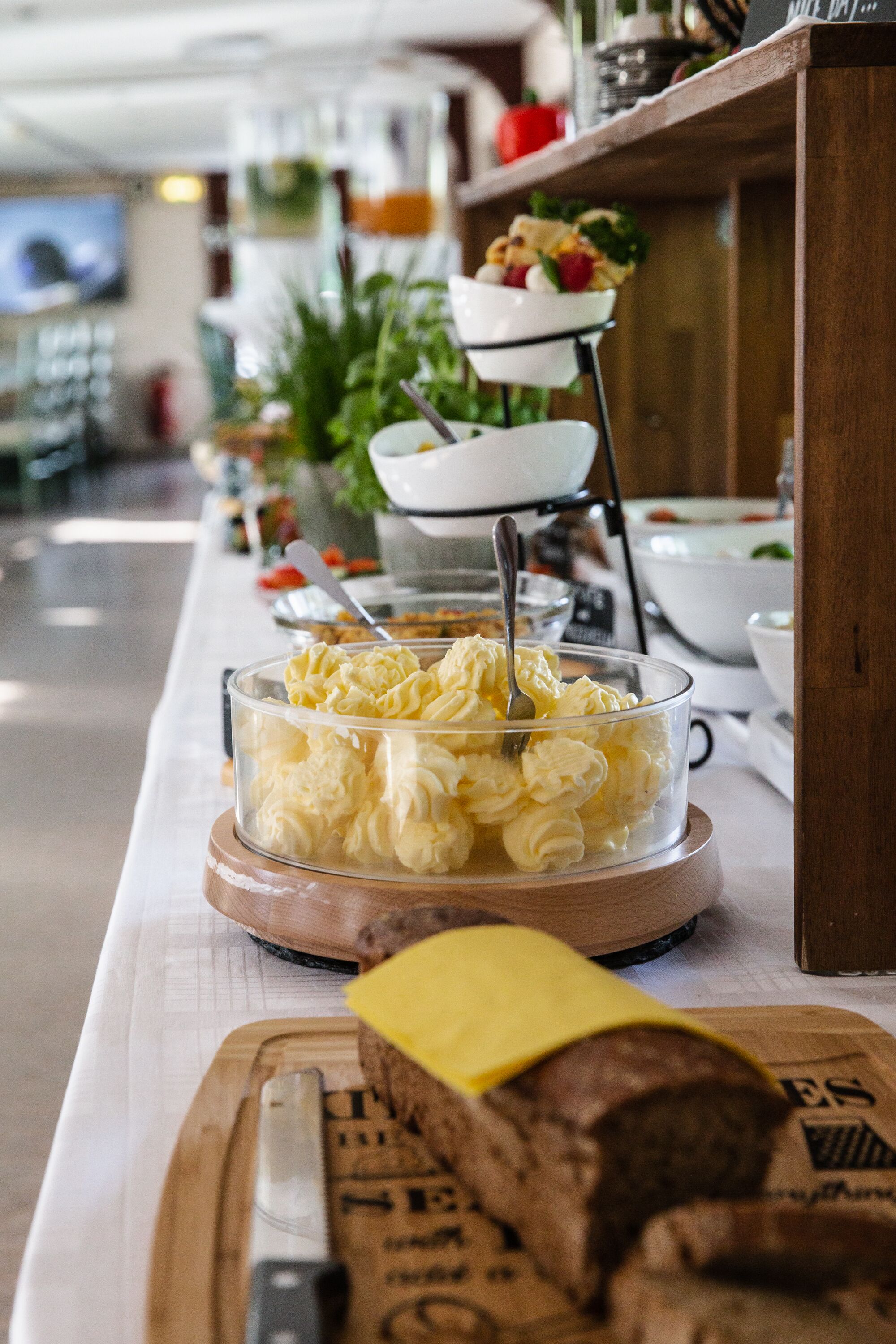 Un buffet proposant une variété de plats, notamment un bol de fromage à la crème et une planche à découper avec un couteau.