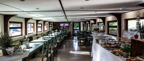 Un comedor amplio con mesas largas, sillas y una disposición tipo bufé.