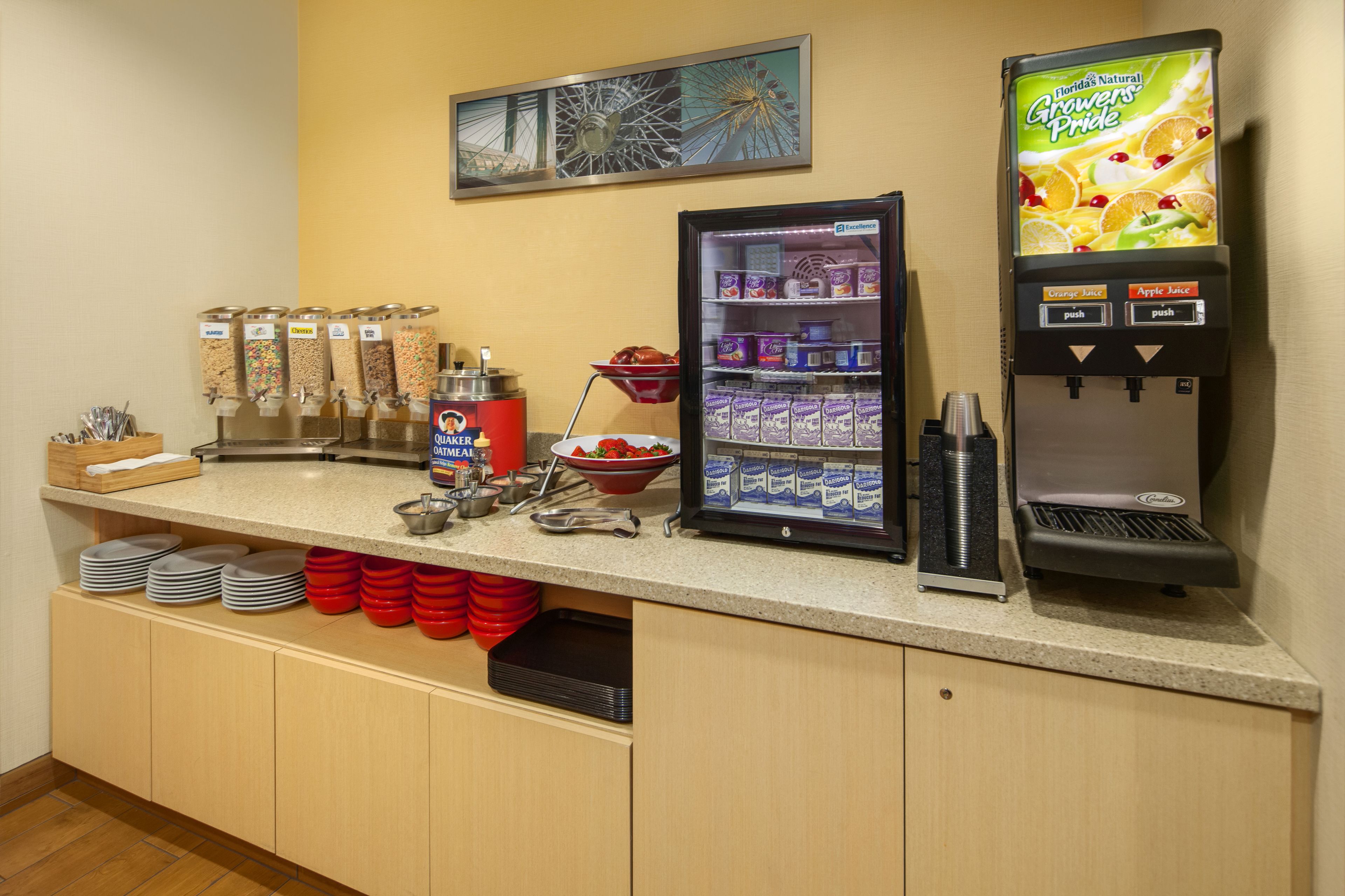 A breakfast bar with a coffee machine, cereal dispensers, and a refrigerated display.