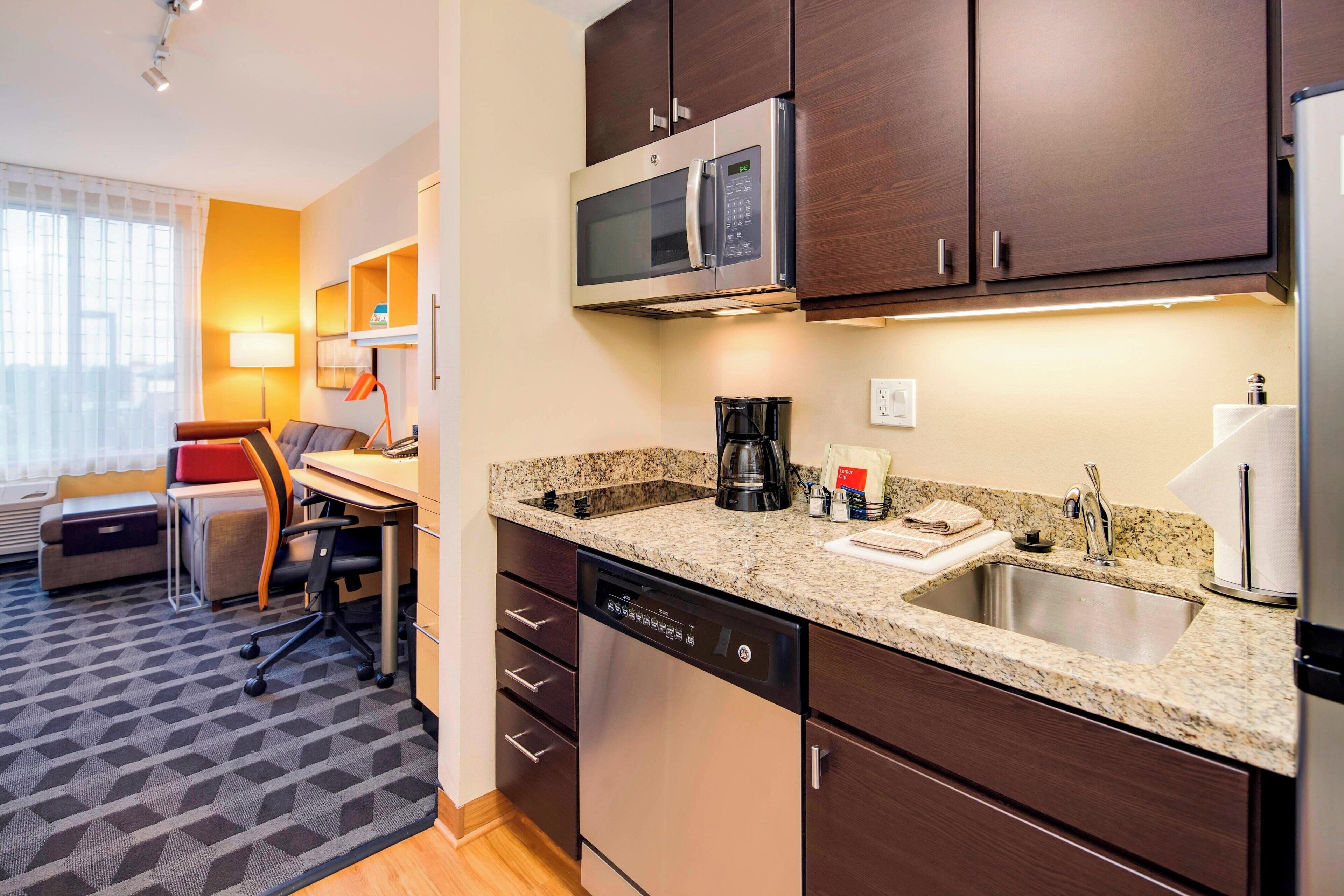A compact kitchen with a microwave, coffee maker, and dishwasher.