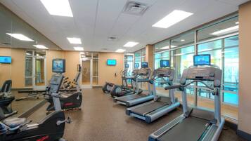 A gym with treadmills, elliptical machines, and stationary bikes.