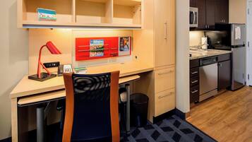 A compact kitchen with a microwave, refrigerator, and a small countertop.