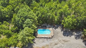 Vista aérea de uma piscina rodeada por vegetação densa.
