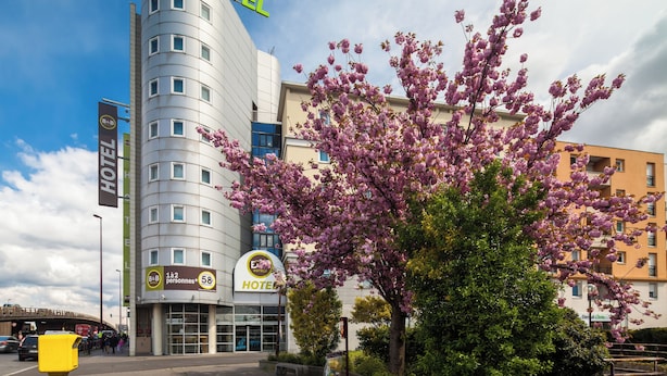 Um hotel moderno com fachada curva, várias janelas e uma placa indicando capacidade para 58 pessoas.