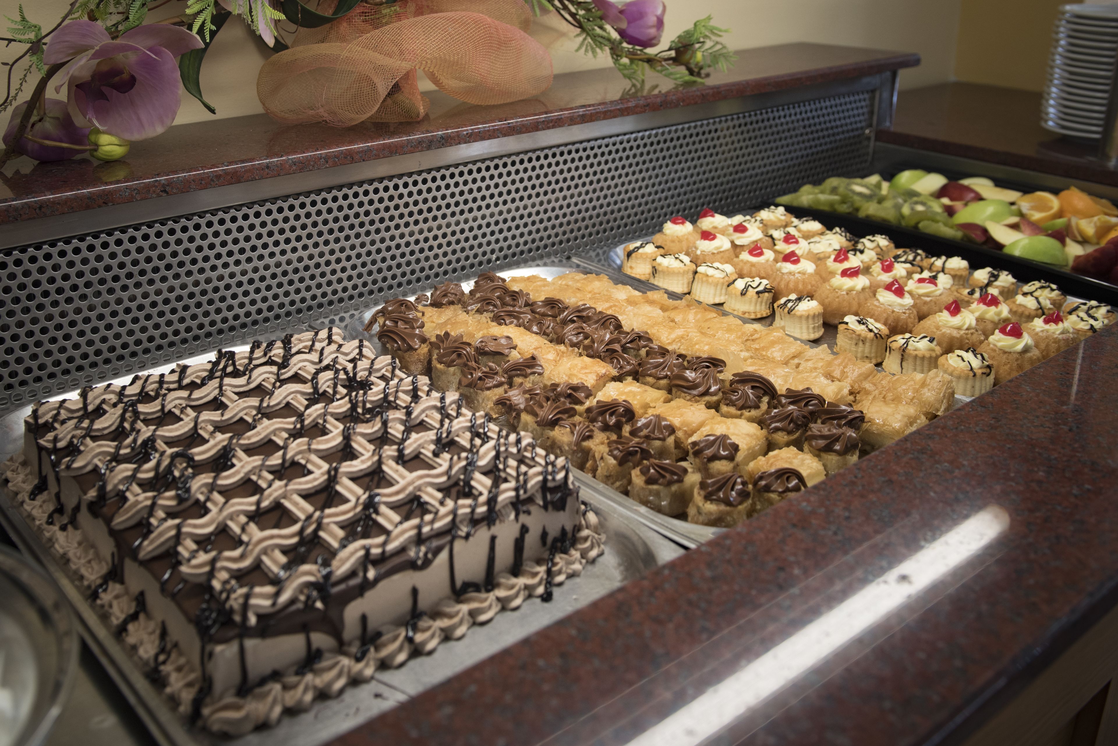 Un bufé con diversos postres, incluyendo pasteles y productos de pastelería.