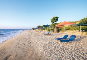 位於海灘上、躺椅、遮陽傘、海灘浴巾