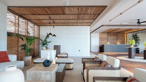 A modern lobby with a high ceiling, wooden beams, and a reception desk. - Kouros Palace Active Lifestyle Hotel (Kos)