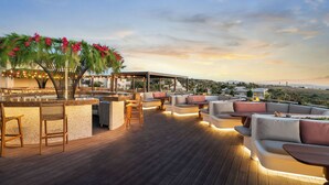 A rooftop bar with seating and a bar counter, overlooking a landscape. - Kouros Palace Active Lifestyle Hotel (Kos)