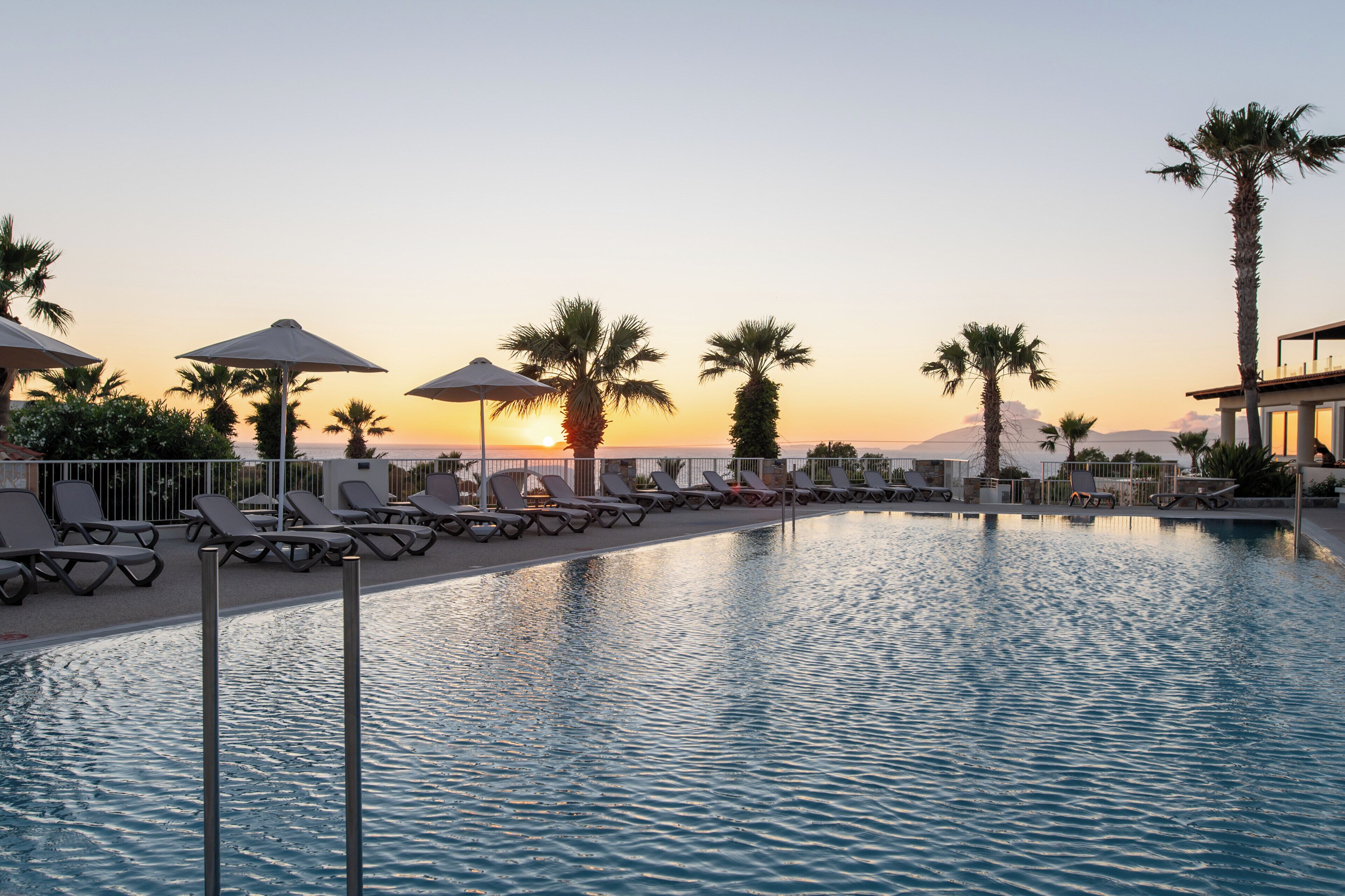 Una piscina al aire libre de temporada, sombrillas