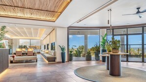 A spacious lobby with a seating area, a round table, and large windows offering a view. - Kouros Palace Active Lifestyle Hotel (Kos)