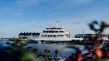 Un ferry grande de varios pisos atracado en un muelle, con un edificio al fondo.