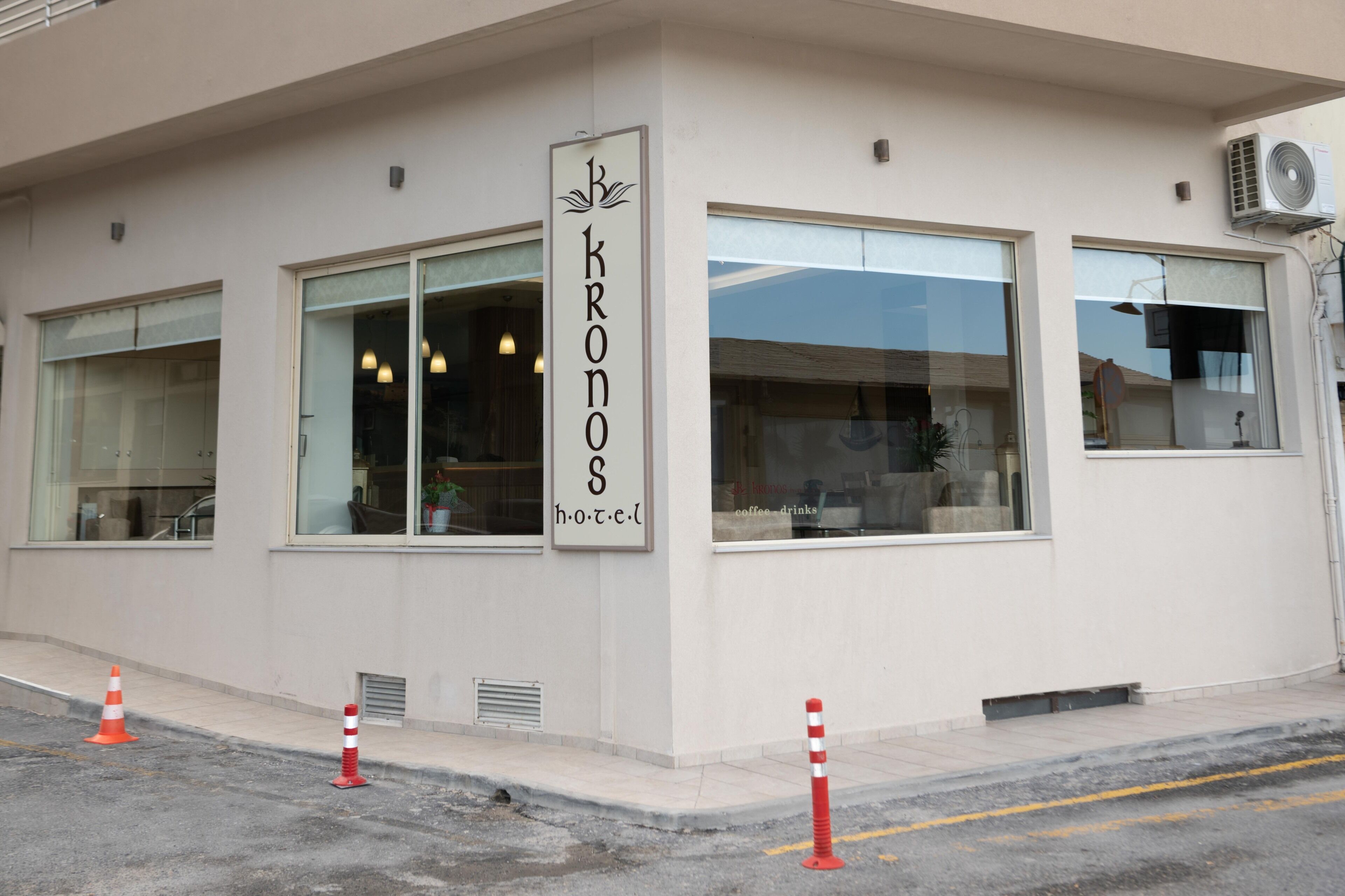 A building with a sign reading "KRONOS h.o.t.c.e.l." and large windows.