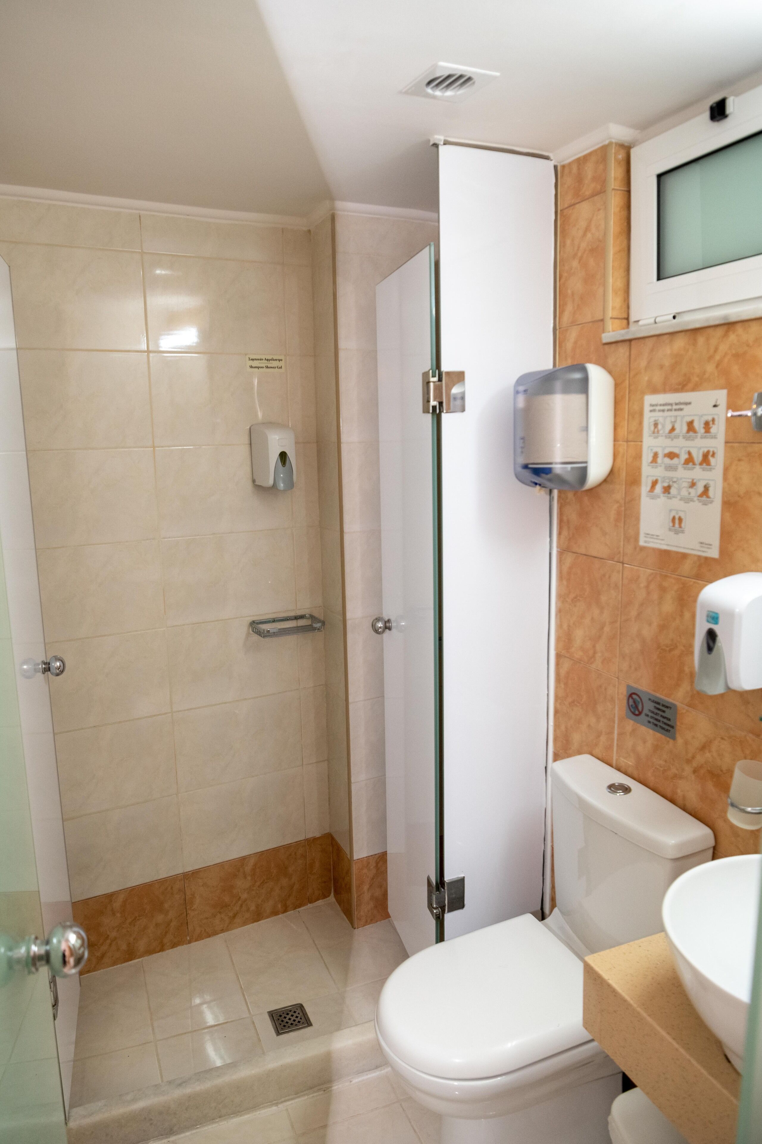 Un bagno con il water, una doccia e un lavandino.