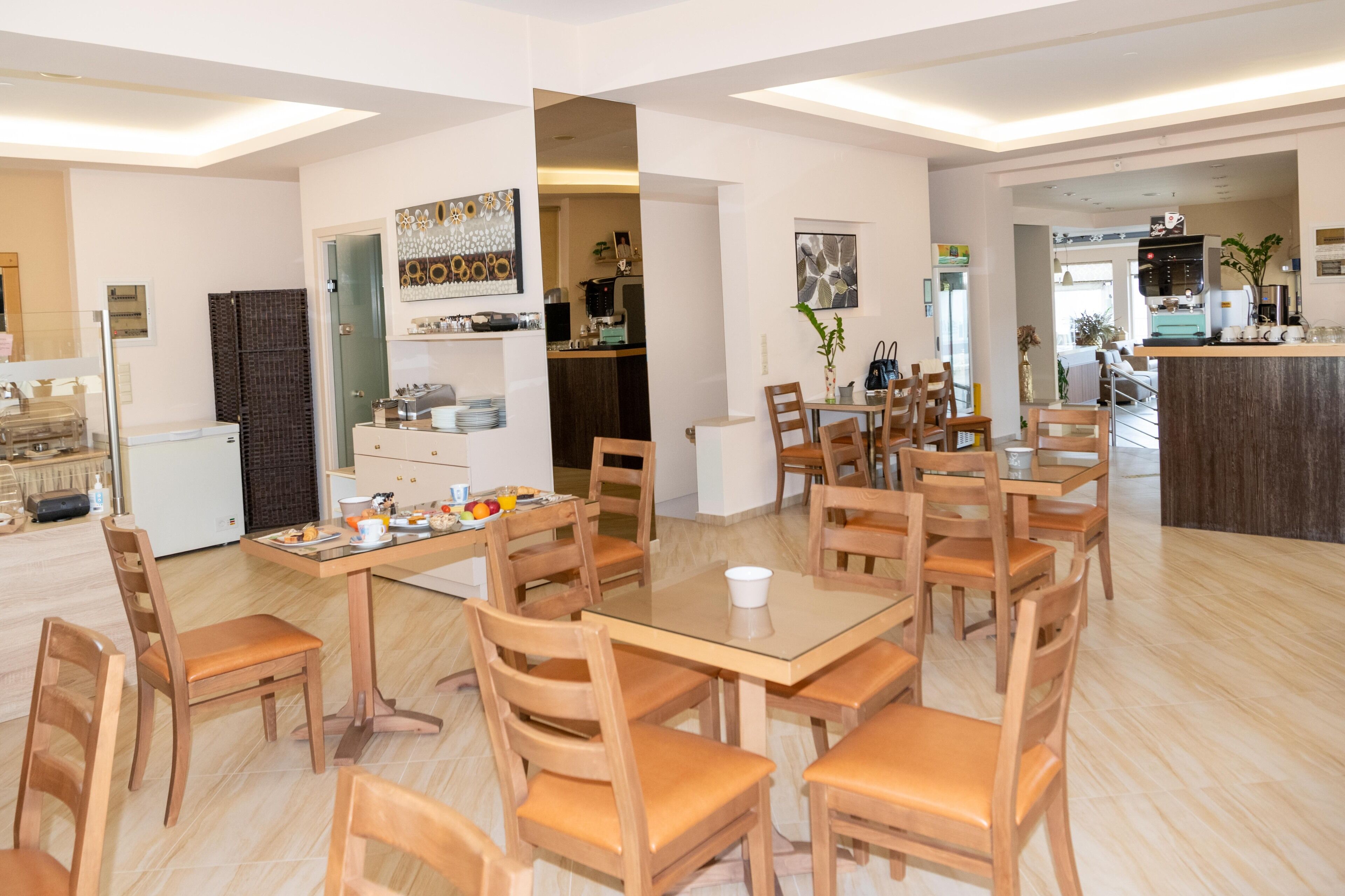 Un'ampia zona pranzo con un tavolo grande e numerosi posti a sedere, una cucina sullo sfondo e un arredamento moderno.