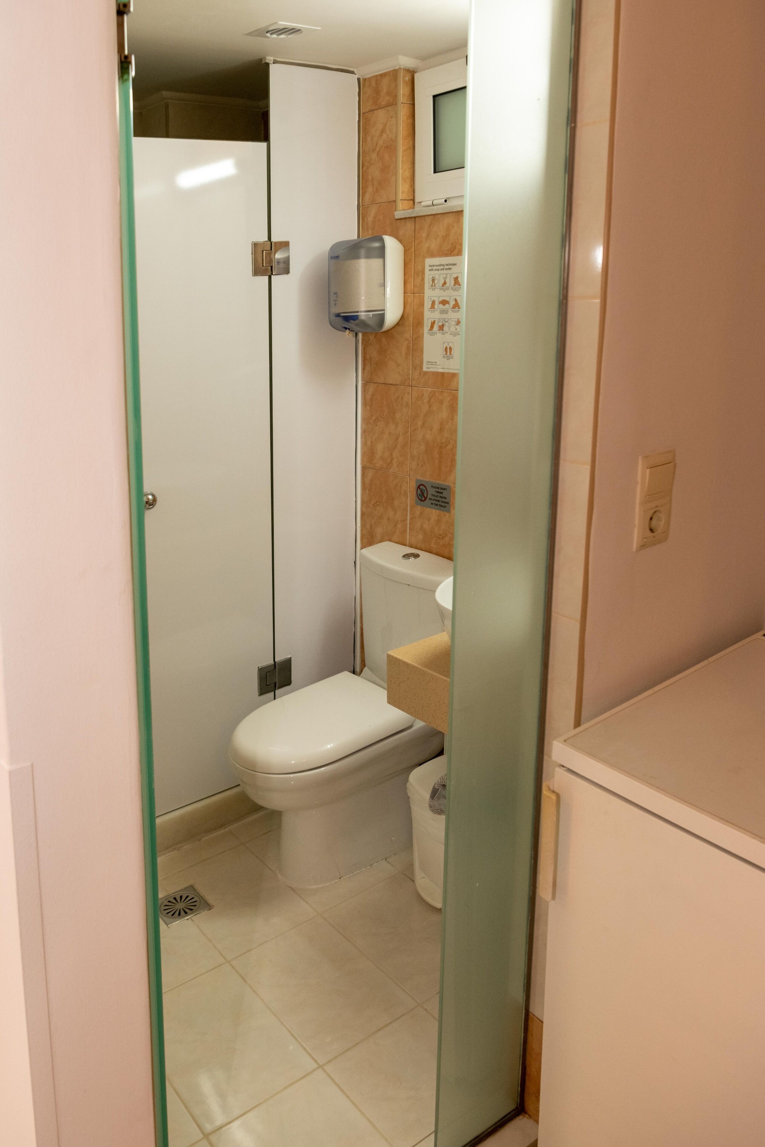 A compact bathroom with a toilet, a sink, and a shower stall.