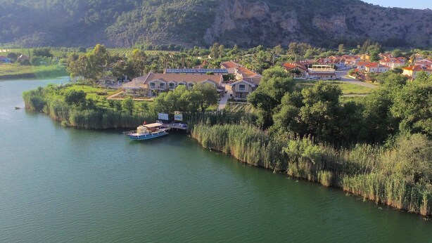 Un pueblo a orillas del río con casas y un barco amarrado.