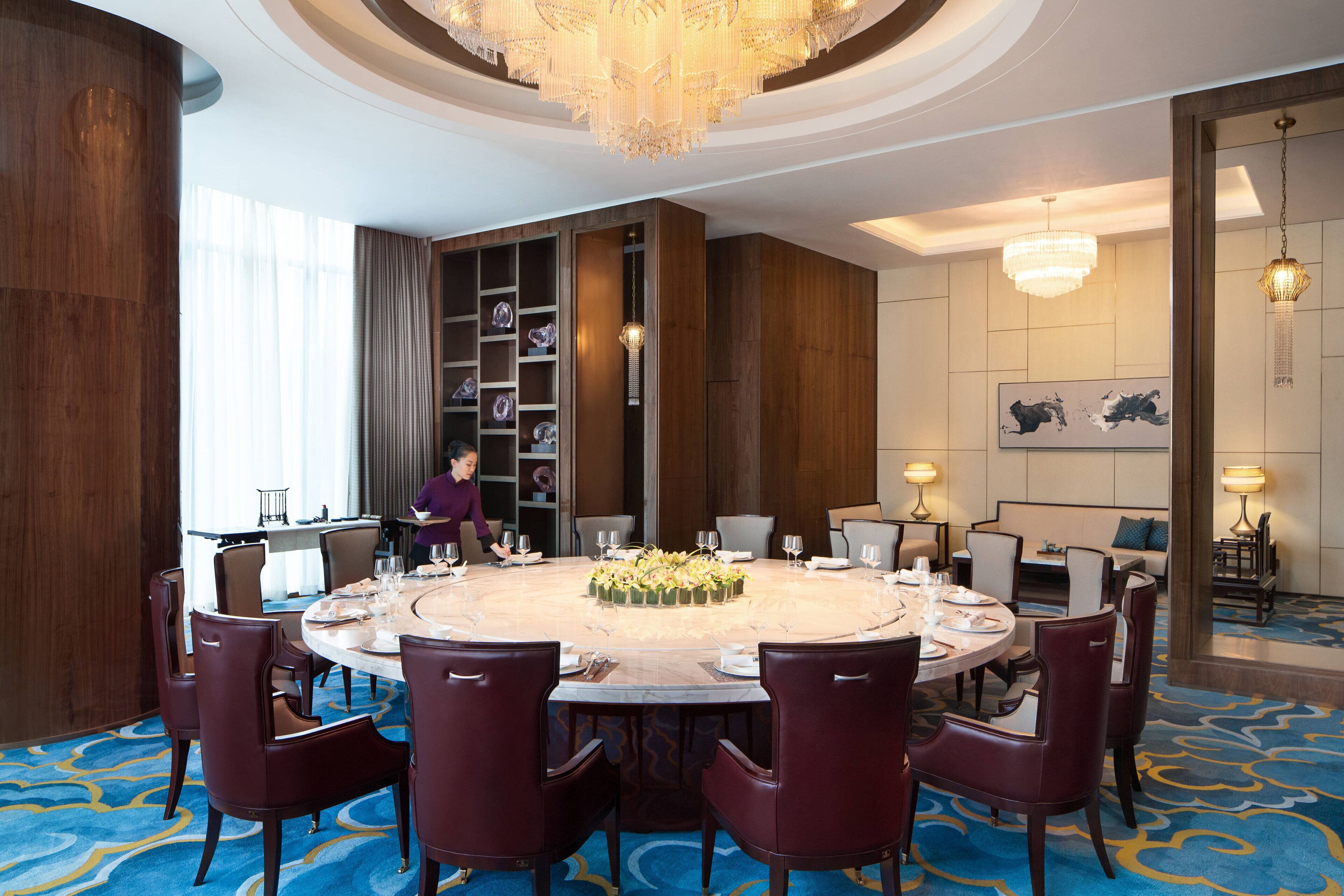 Ein Konferenzraum mit rundem Tisch, Stühlen und einer Chandelier.