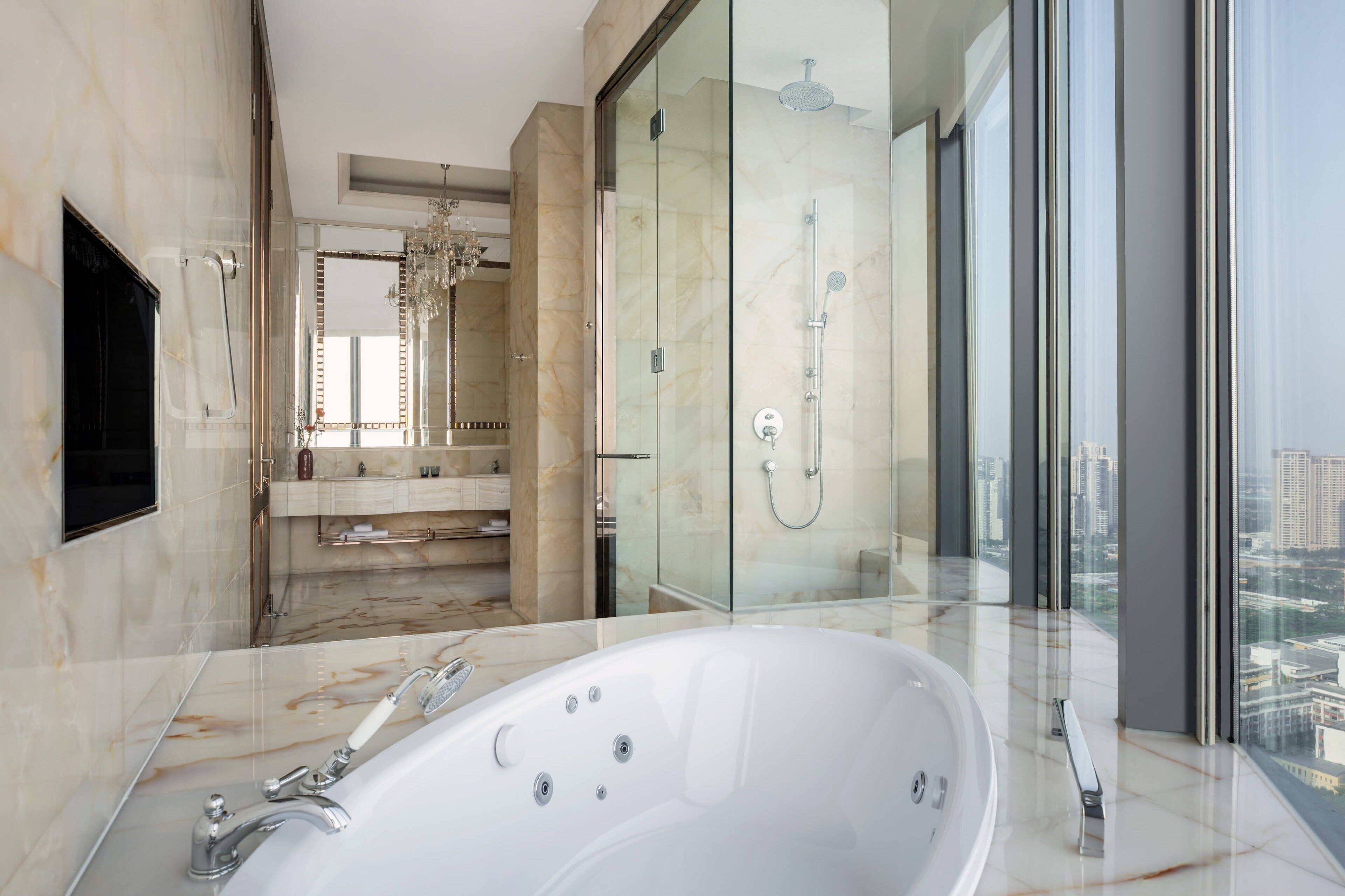 Ein modernes Badezimmer mit einer großen Badewanne, einer Duschkabine und einem Waschtisch mit Spiegel.