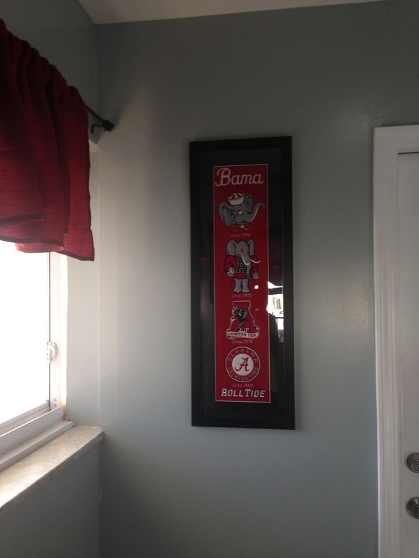 A framed poster on a wall with a window and a door.