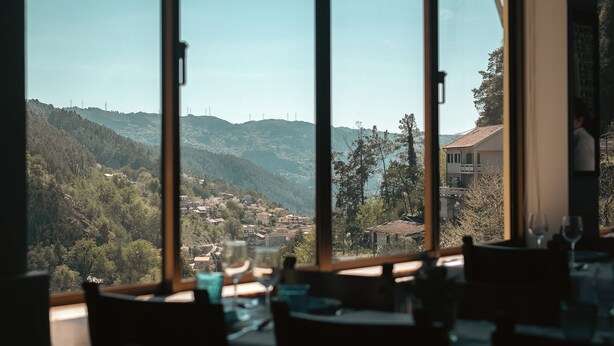 A dining area with large windows overlooking a valley. - Adelaide Hotel (Terras de Bouro)