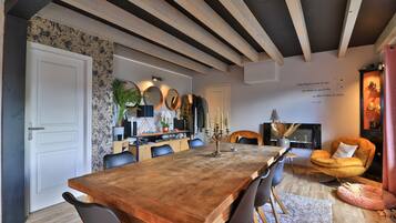 A dining area with a wooden table, black chairs, and a fireplace.